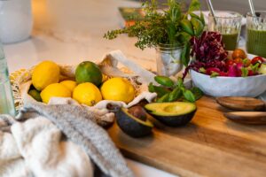 lemons, avocado and herbs on a cutting board in a kitchen